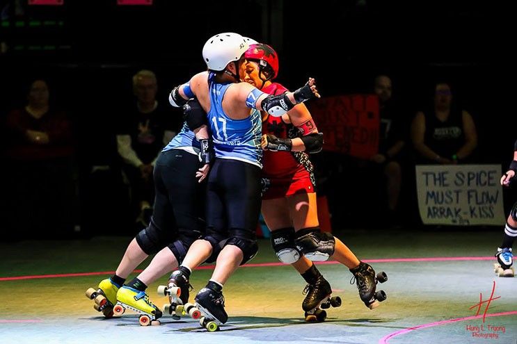 Houston Roller Derby and Brawler skater number 17 AcuPunchHer blocks Psych Ward Siren player EnJen.