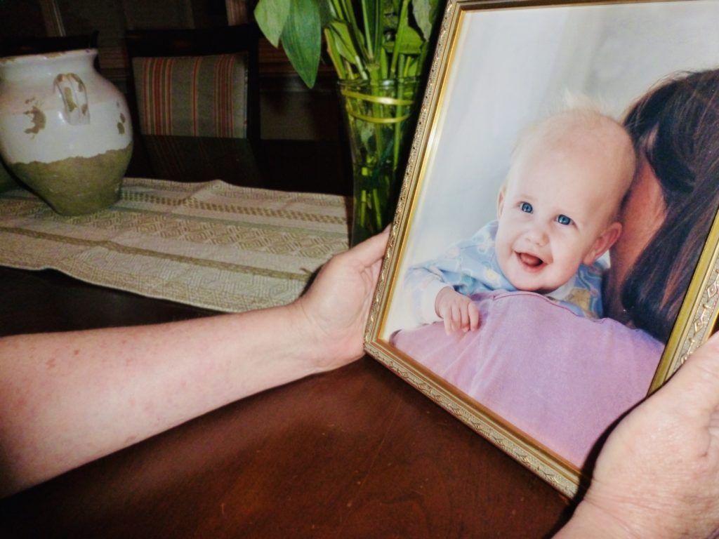A photo of the mother of Jay Stracke holding his baby photo.