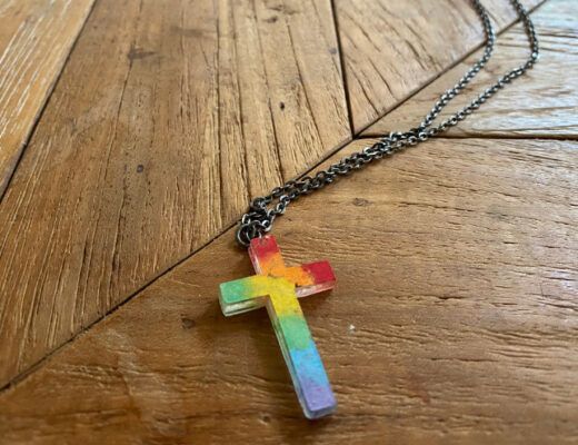 A photo of queer kids Christian necklace.