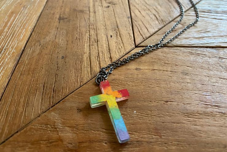 A photo of queer kids Christian necklace.