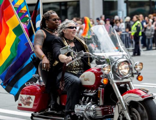 A photo of queer women motorcycling.